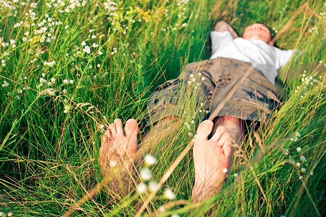 Mann liegt schlafend im Gras