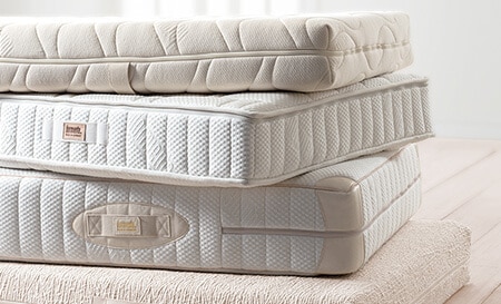 Futonmatratze, Deluxe Matratze, Classic Matratze und Natural Matratze von dormiente auf einem Stapel
