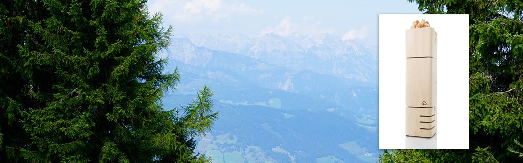 Zirbenraumlüfter von Allpine und im Hintergrund Zirbenkieferbäume und ein Gebirge in Salzburg